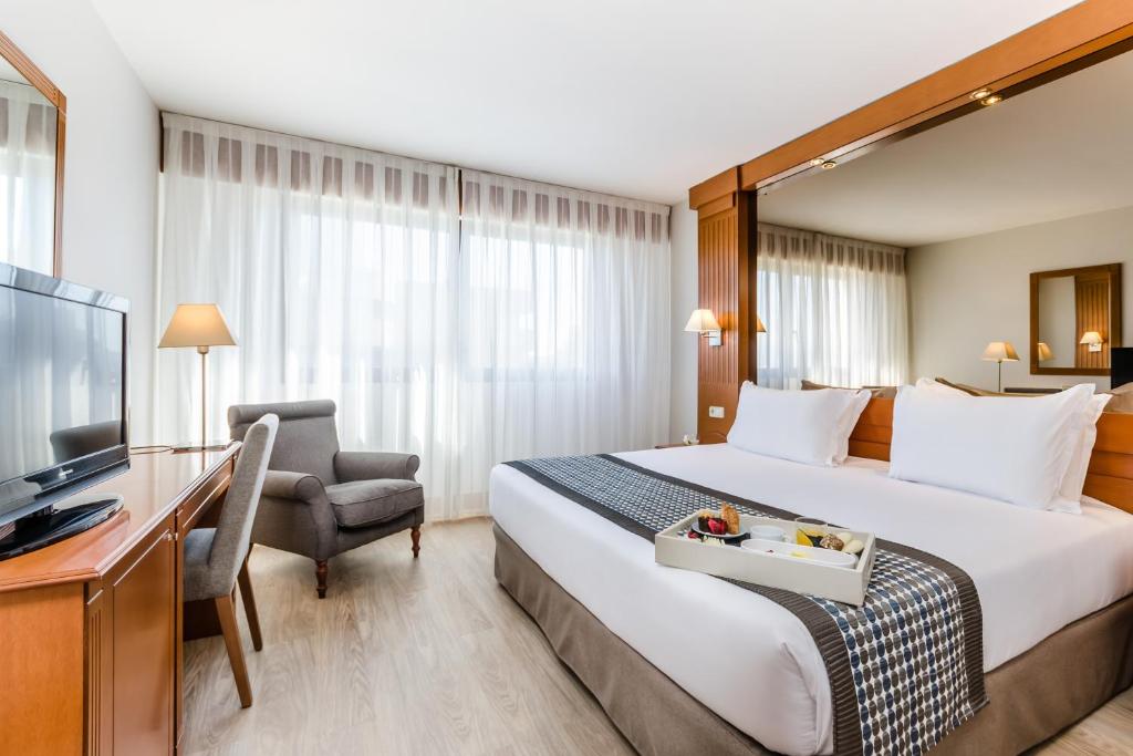 贝拉特拉埃克斯校园旅馆的酒店客房设有一张大床和一台电视。