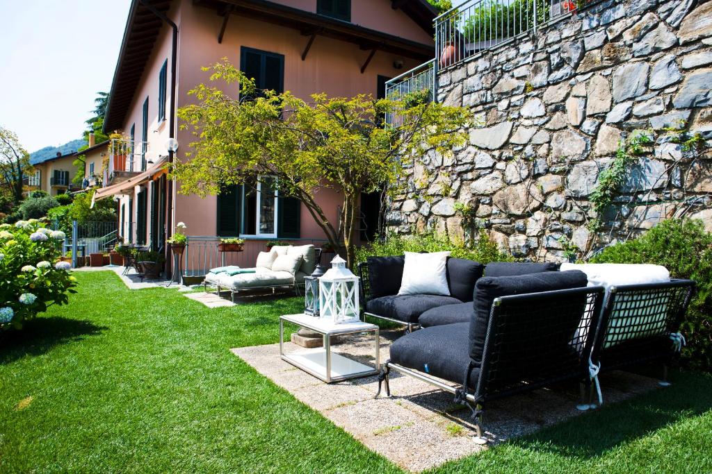 贝拉吉奥Belvedere Holiday Home的坐在石墙旁的院子中的沙发