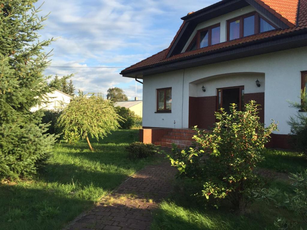什切青Landhaus mit Garten的庭院内有一条小路的白色房子