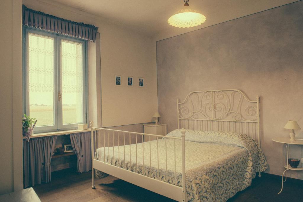 贝内瓦吉恩纳La Vigna Del Maestro的卧室配有白色的床和窗户。