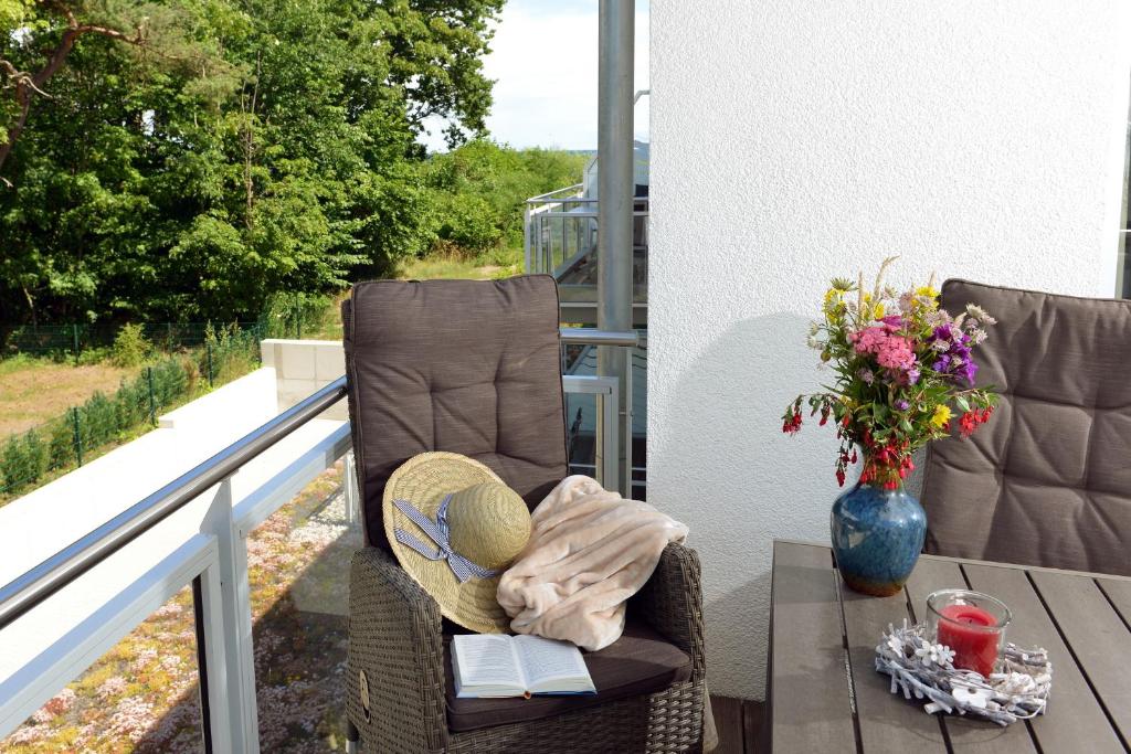 朱列斯拉赫Ferienwohnung Sonnensegler的阳台上的椅子,带桌子和花瓶