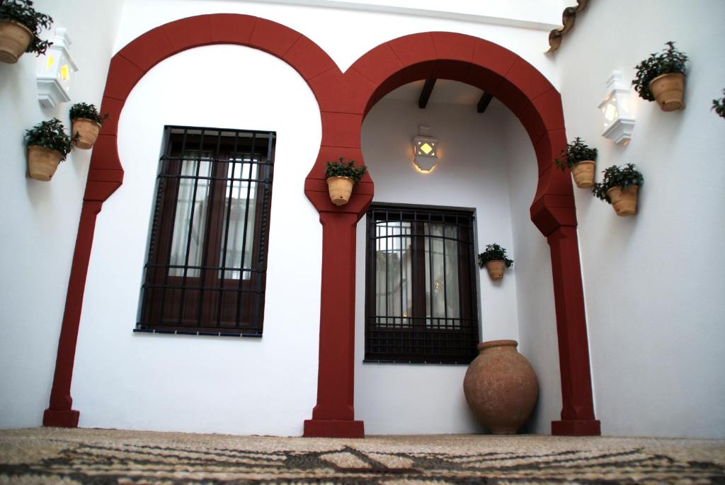 科尔多瓦帕提欧阿克若斯度假屋的白色的建筑,有红色的拱门和窗户