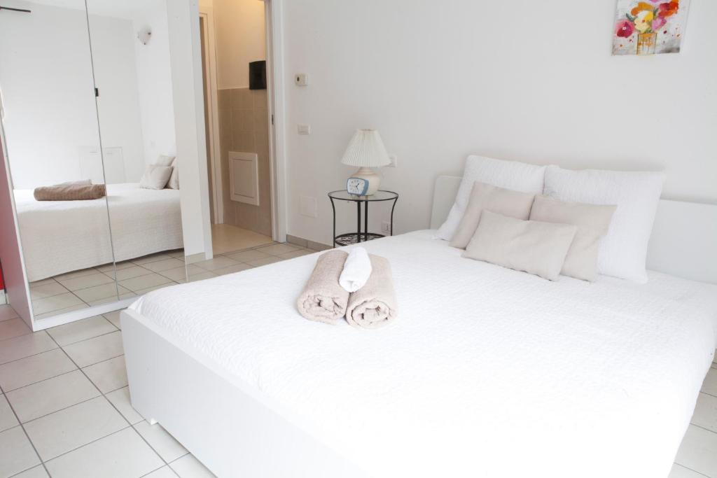 米兰阿莱西亚洛雷托公寓的卧室配有白色的床和2条毛巾