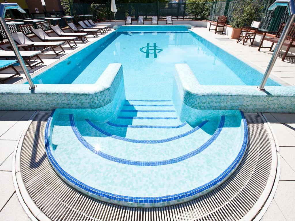 里米尼盖比酒店的游泳池周围设有楼梯和椅子