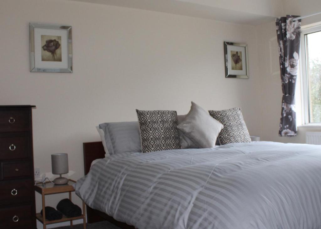 卡菲利Castell Cottages的卧室配有带枕头的床铺和窗户。