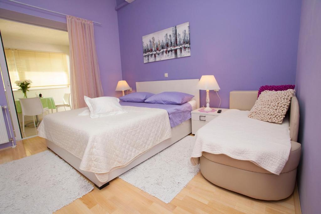 马卡尔斯卡Villa Palma Apartments的紫色卧室配有两张床和一把椅子
