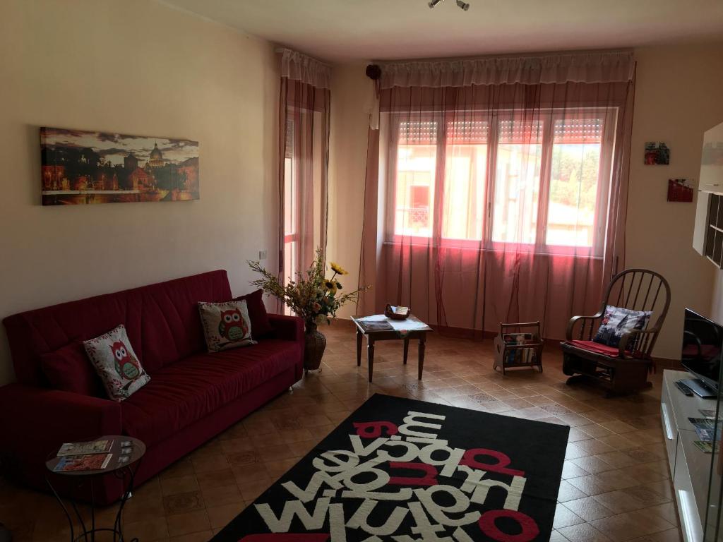 阿里恰比格家庭公寓的客厅配有红色沙发和地毯。