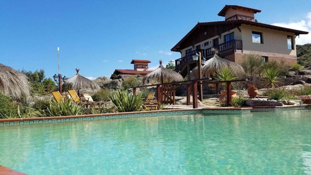 坎伯雷塔Aires Serranos - Suites的一座带游泳池的度假村,位于一座建筑前