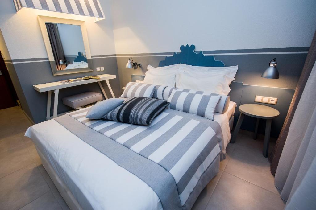 帕蒂迪里奥阿尔基奥酒店的一间卧室配有一张蓝色和白色条纹的床