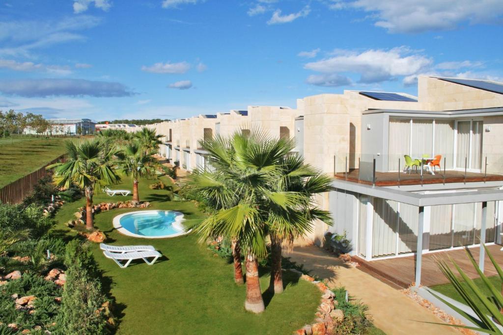 莱斯卡拉里衣卡拉度假酒店的享有带游泳池和棕榈树的别墅的空中景致