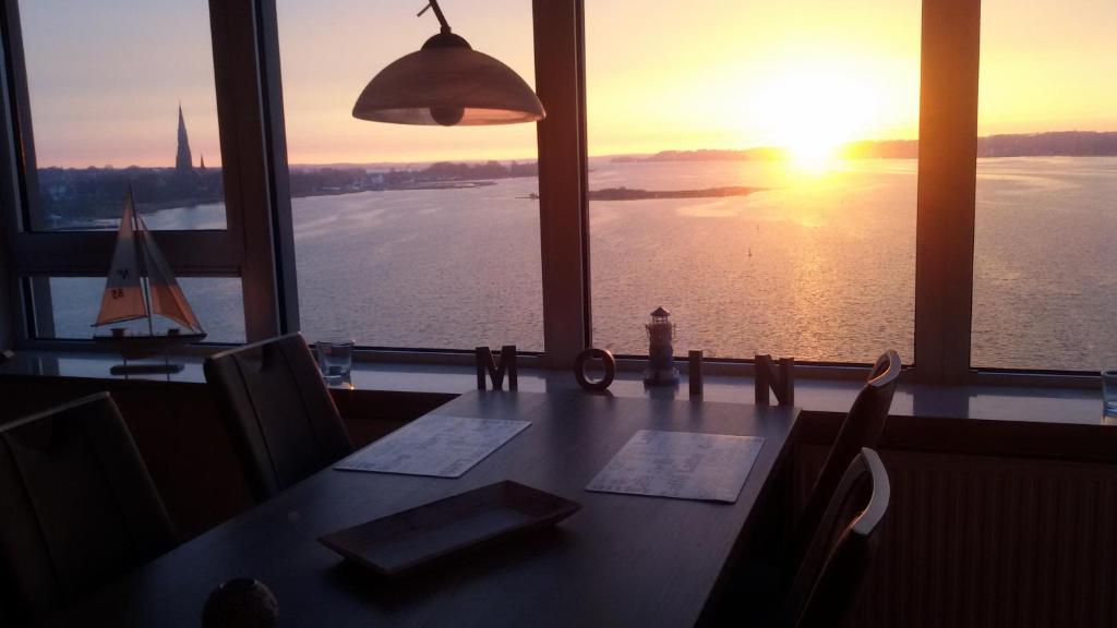 石勒苏益格Ostseefjord-Schlei-Blick im Wikingturm的一间带桌子和水面帆船的用餐室