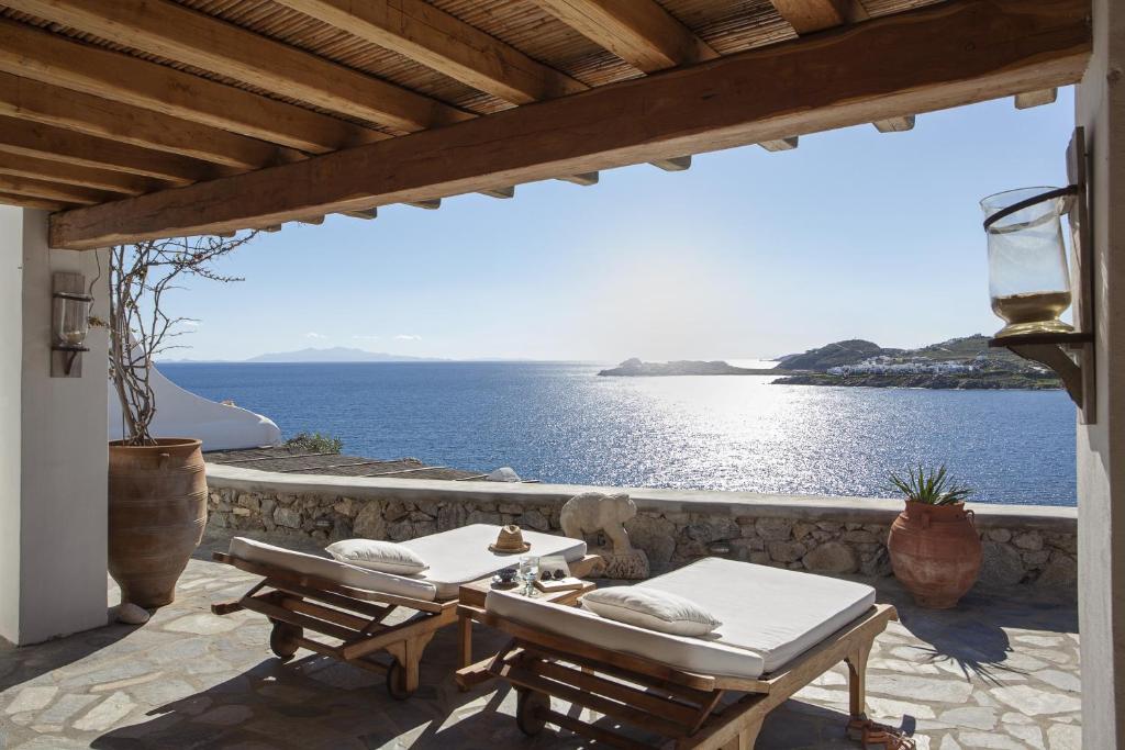 奥诺斯Beachfront Mykonos Guest House的一个带两张桌子的海景庭院