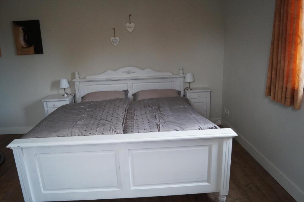 Benk en DonkBed en Breakfast Donkersvoort的一张白色的床,房间有两个床头柜