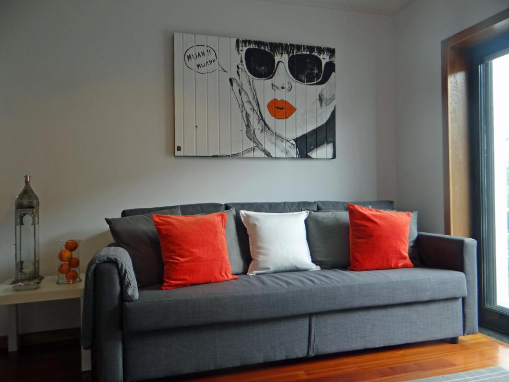 波尔图S. João Porto Apartment的蓝色的沙发,配有橙色和白色的枕头