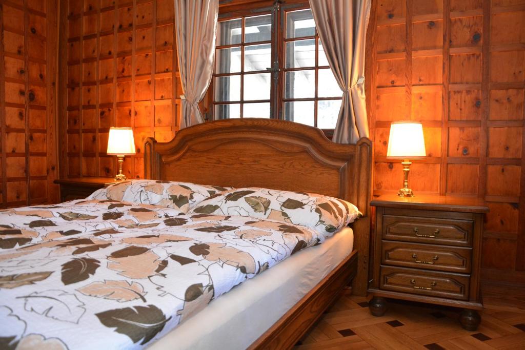 玛丽亚温泉Apartman Forstamt Glatzen Kladska的一间卧室配有一张床、两盏灯和一个窗户。