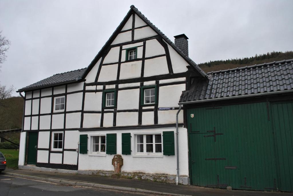 格明德Ferienwohnungen Türmchen的白色绿色的房子,设有绿色车库