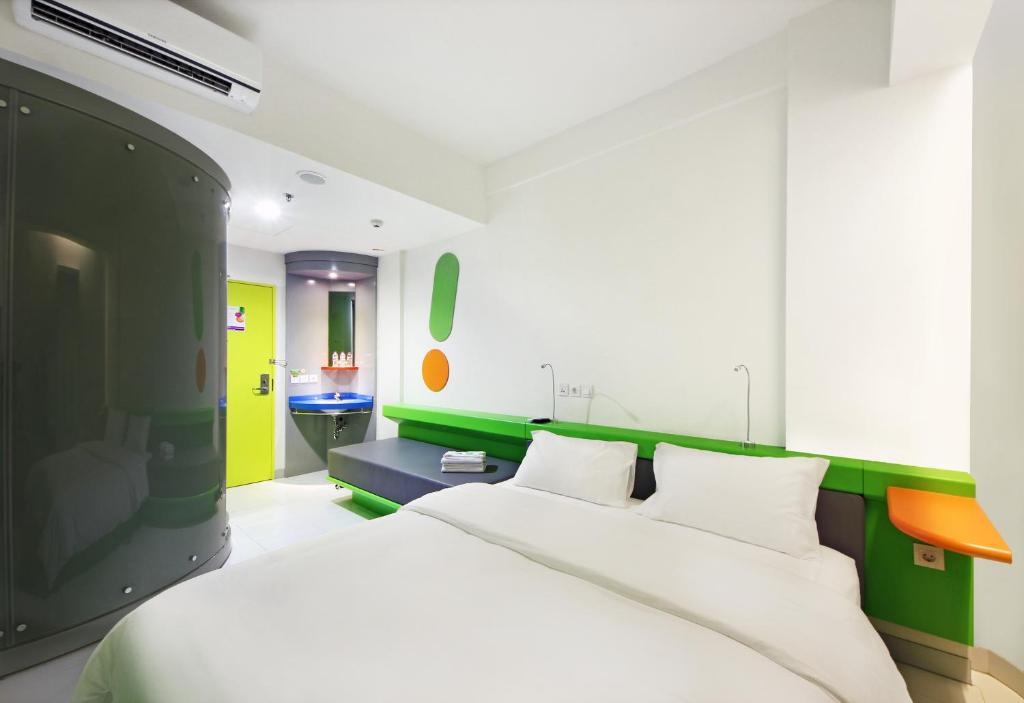 塞尔蓬波普丹格朗BSD城酒店 的卧室配有白色的床和绿色的墙壁