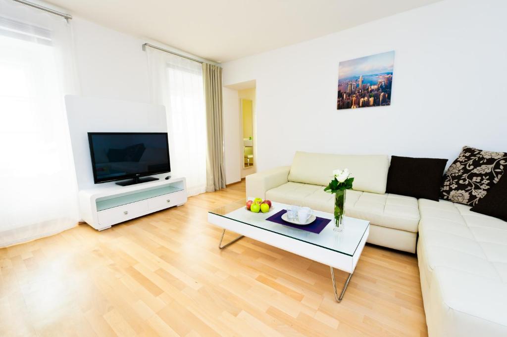 维也纳VOX设计酒店的客厅配有白色沙发和电视
