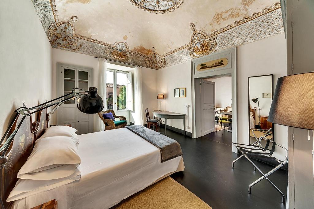 科米索Palazzo Melfi的一间卧室配有一张床,另一间卧室配有桌子