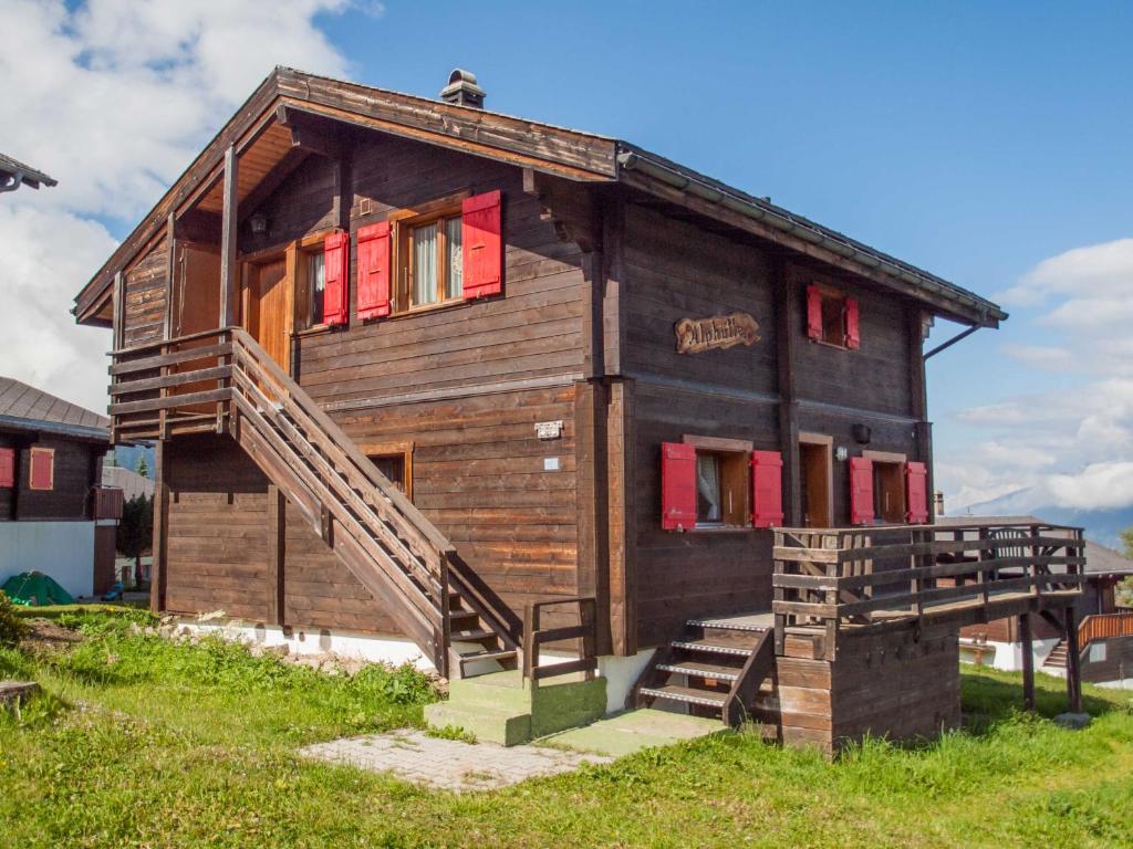 RosswaldChalet Alphütte的一间木制房子,设有红色的窗户和楼梯