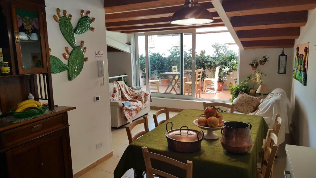 巴勒莫PalermiT'Amo的厨房以及带绿桌布的餐桌的用餐室。
