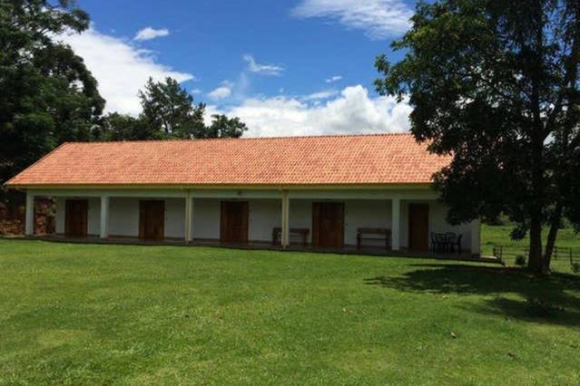 圣安东尼奥-杜皮尼亚尔Recanto da Maya的一座有红色屋顶和草地庭院的建筑
