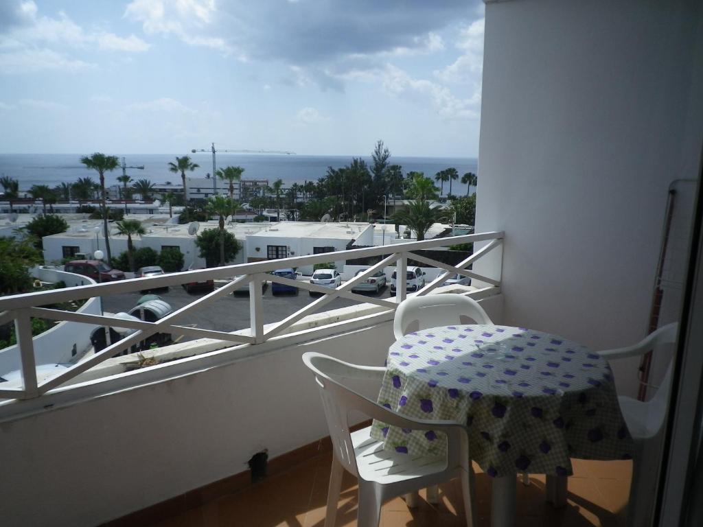 卡门港Viviendas Las Vistas的阳台配有桌椅,享有海景。