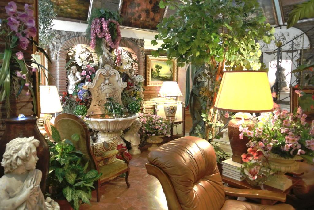 罗马巴雷特酒店 的客厅里摆放着许多鲜花和家具