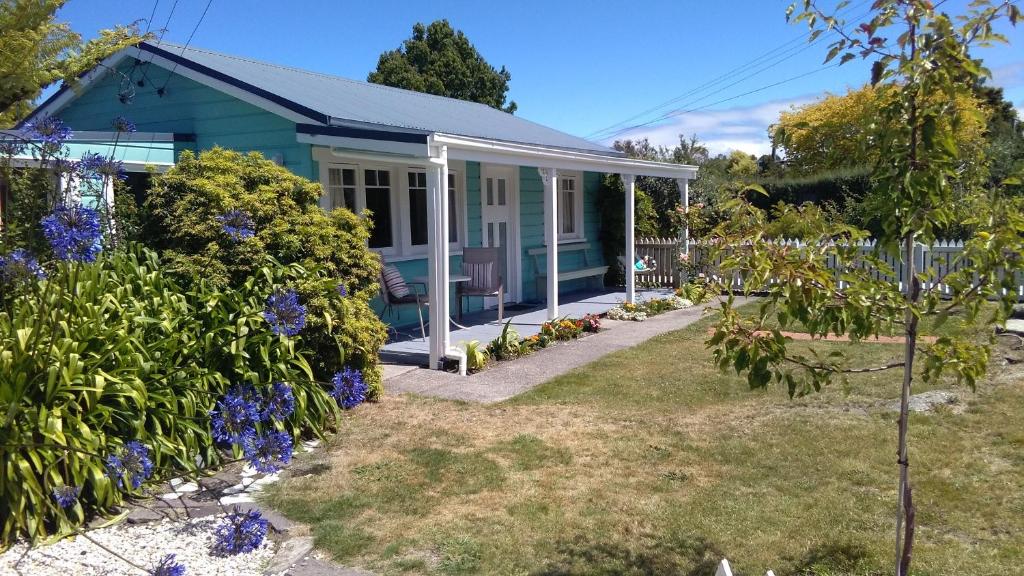 玛普瓦Ferntree Cottage的院子里鲜花盛开的蓝色房子