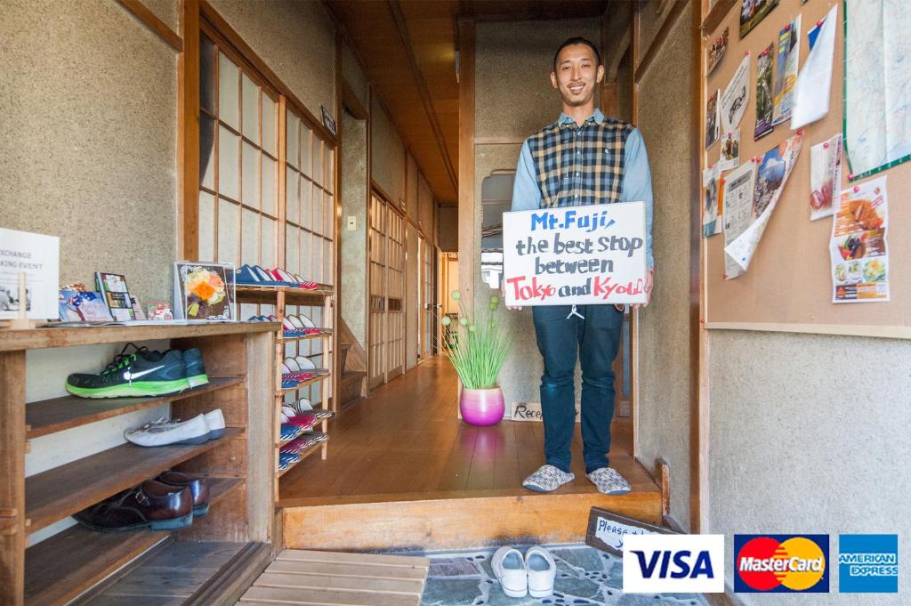 富士市纳思比富士山背包客旅馆的站在走廊上,手持标志的人