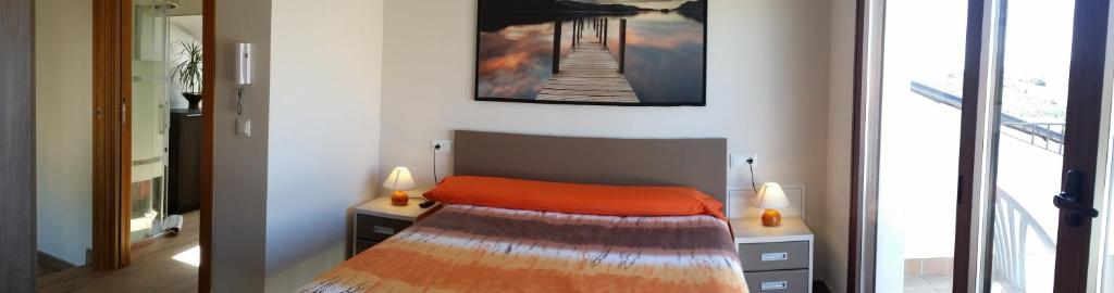 Lorca塞克玛度假屋的一间卧室配有一张带橙色毯子的床