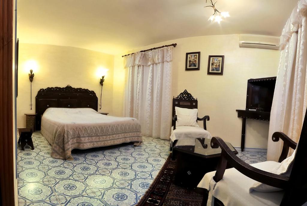艾格-莫尔特马斯德拉蒙迪尔旅馆的一间带两张床的卧室和一台电视
