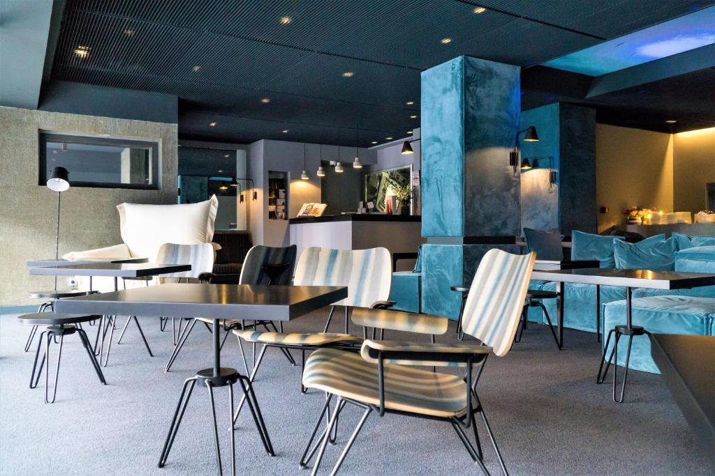 雅典潜望镜酒店的一间带桌椅的餐厅和一间酒吧