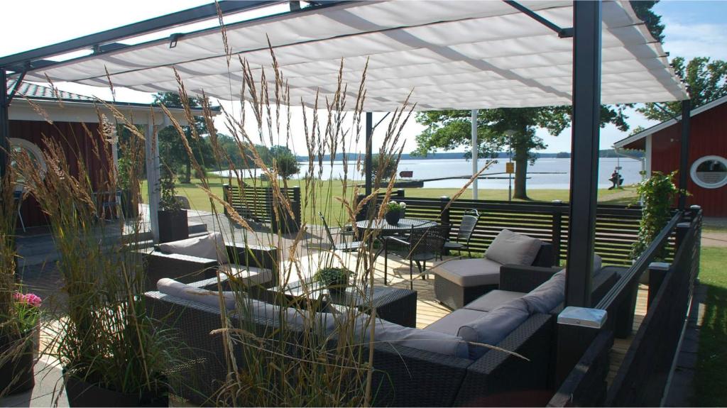 TingsrydTingsryd Resort的一个带顶棚、沙发、椅子和桌子的庭院