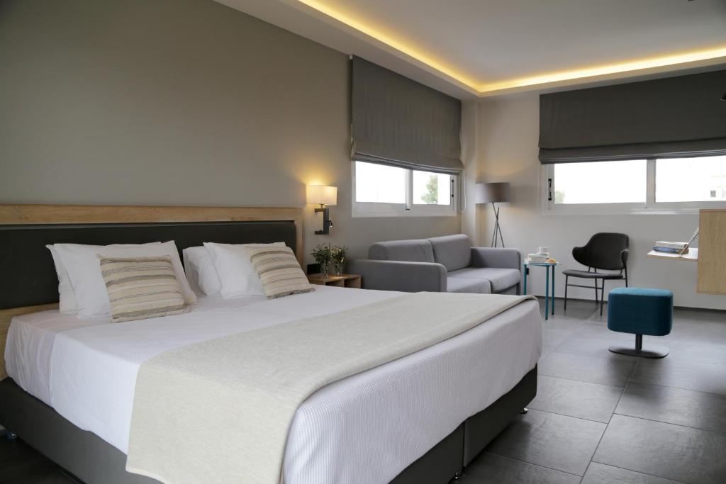 雅典巴尔米拉海滩酒店的一间带白色大床的卧室和一间客厅
