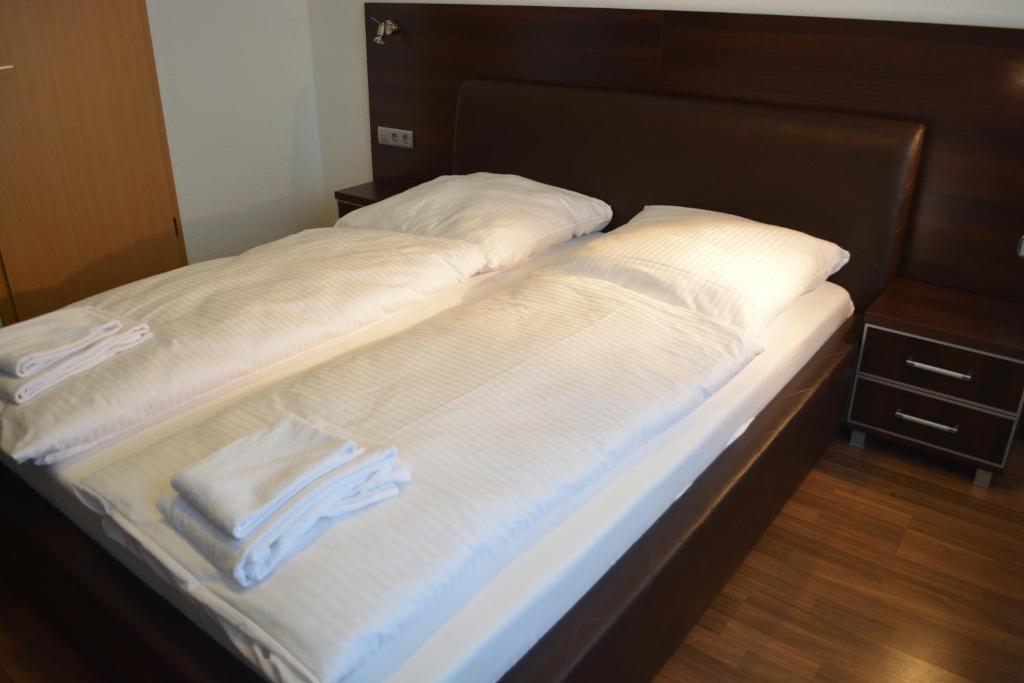 汉诺威B&D酒店的一张带白色床单和毛巾的床
