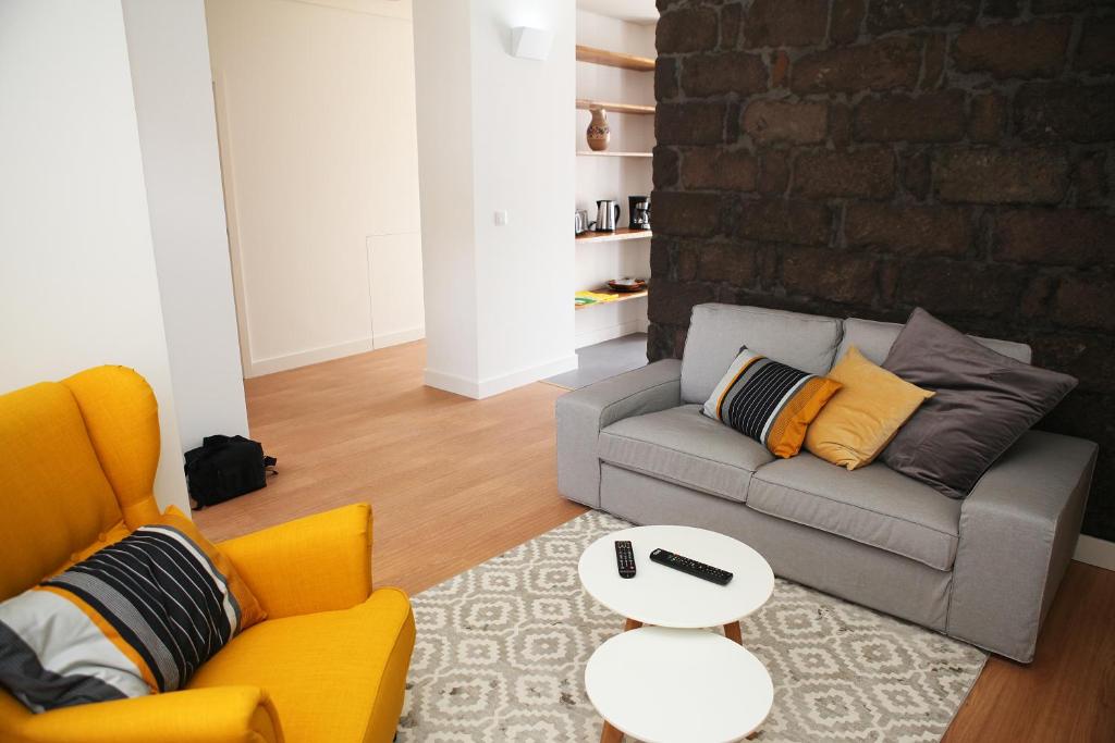 波瓦桑Casa da Cisaltina的带沙发和砖墙的客厅