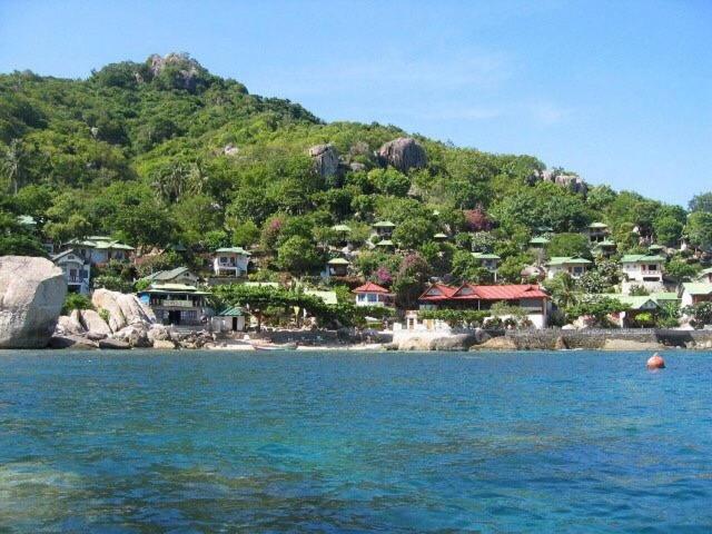 涛岛塔诺特贝家庭度假酒店的水中的小岛上,小岛上的山丘上设有房屋