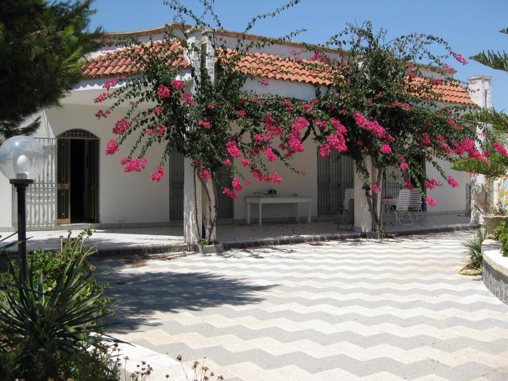 切萨雷奥港Villa Bouganville的一座庭院,房子前有粉红色的花朵