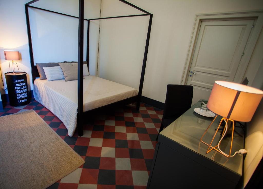 巴格里亚Le stanze del Capostazione的一间卧室配有一张床和一张带台灯的桌子