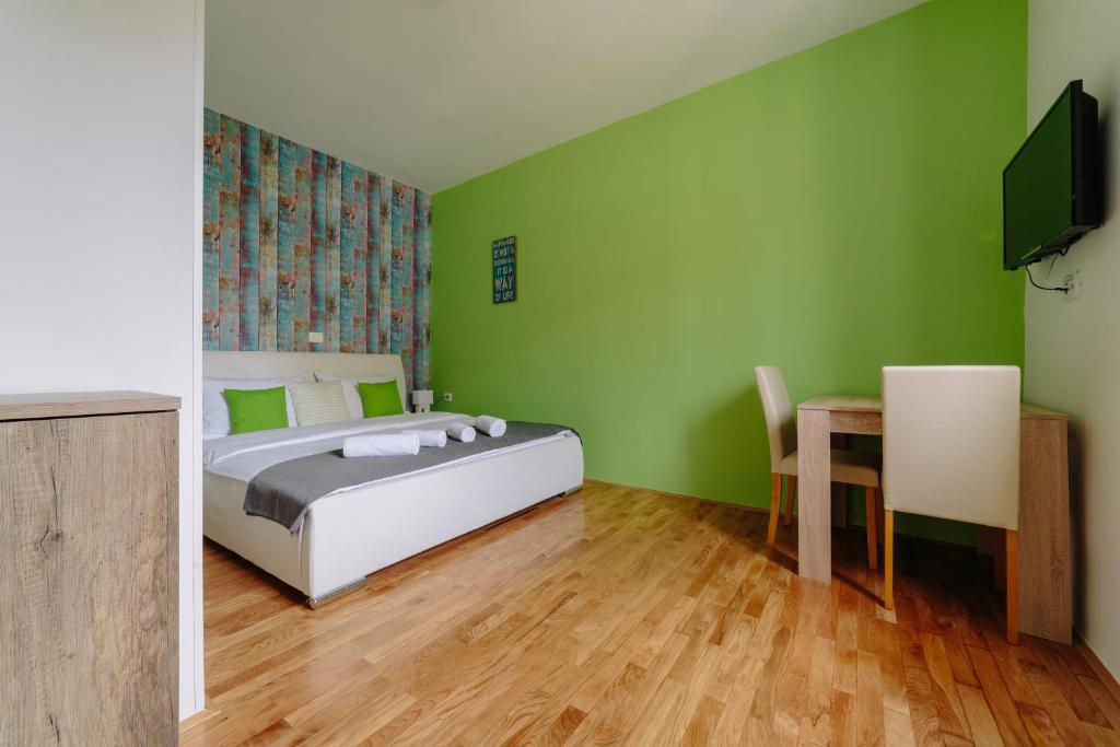 皮兰Piranika的一间卧室设有绿色的墙壁、一张床和一张桌子
