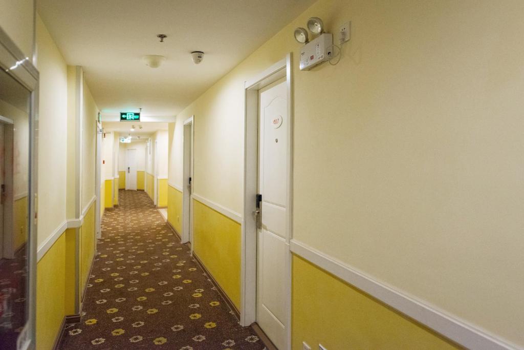 海门如家快捷酒店海门人民西路体育场店的医院走廊的走廊,有黄色和白色的墙壁