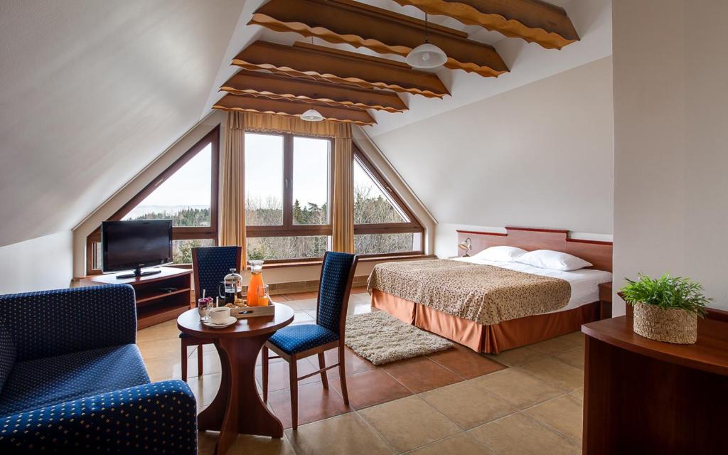 波德古任康坎迪亚酒店的酒店客房带一张床、一张桌子和椅子