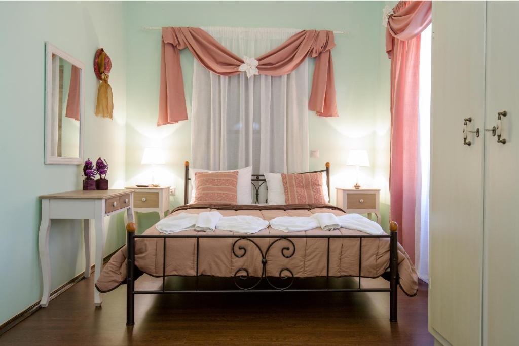 干尼亚波尔图之家酒店的一间卧室配有床和一个带粉红色窗帘的窗户。