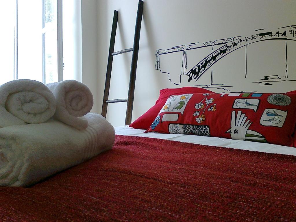 波尔图Formosa Oporto Apartments Group的一间卧室配有一张带红色毯子和床架的床