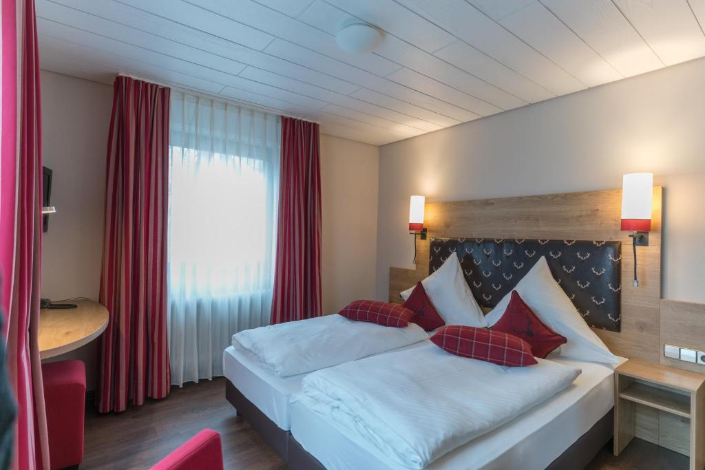 莱茵河畔凯尔黑尔茨酒店的配有一张床、一张书桌和一扇窗户的酒店客房