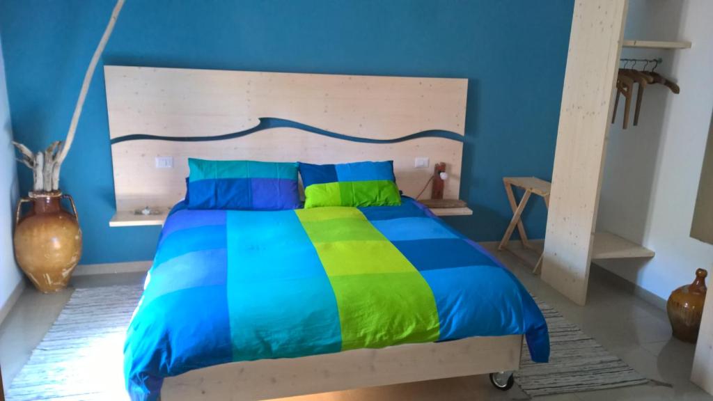 巴里拉万提诺住宿加早餐旅馆的一间卧室配有一张色彩缤纷的床和蓝色的墙壁