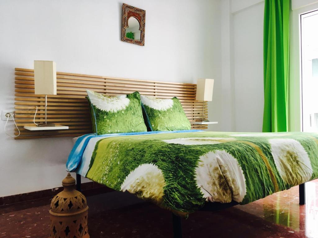 内尔哈克斯奎雅公寓的卧室配有一张带绿床单和枕头的大床。
