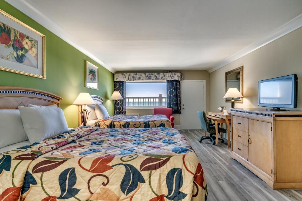 默特尔比奇Beachcomber Inn & Suites的酒店客房设有两张床和一台平面电视。
