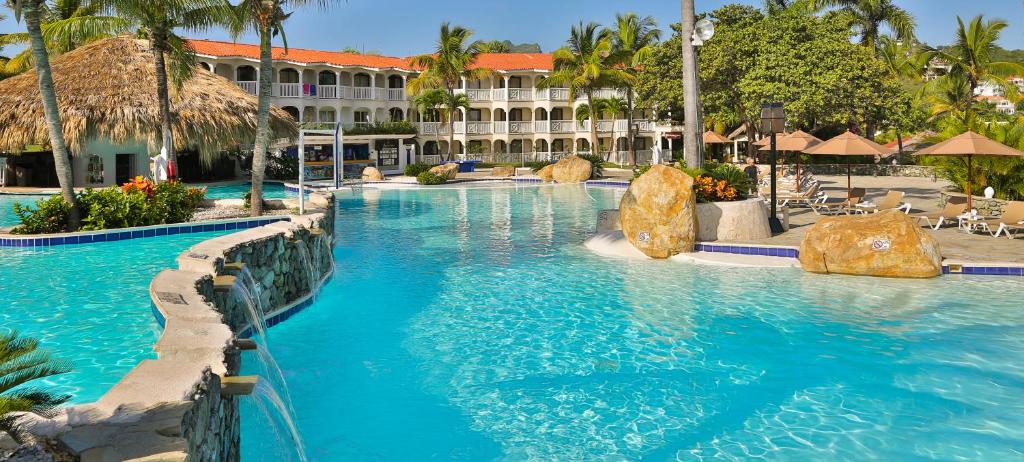 圣斐利-银港Lifestyle Tropical Beach Resort & Spa All Inclusive的蓝色海水度假村内的游泳池